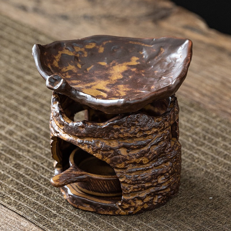 Side view of the tree stump tea warmer, highlighting the hand-polished base and leaf-shaped saucer.
