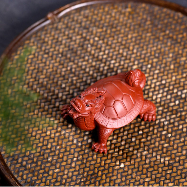 Close-up of the Yixing clay dragon turtle tea pet in use, with tea being poured over it to enhance its luster.