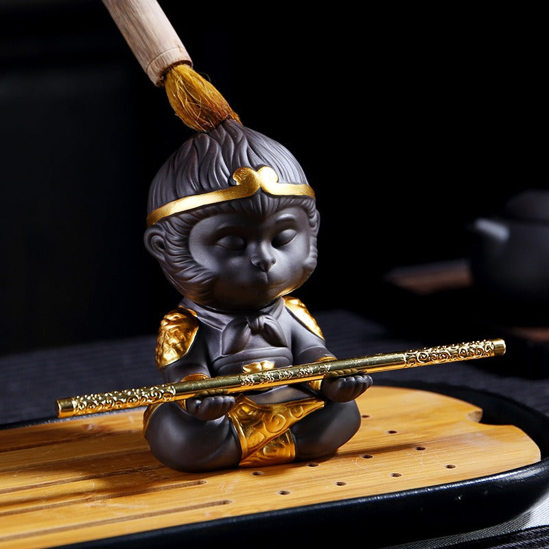 Handcrafted purple clay Wukong tea pet with detailed carving on a tea tray