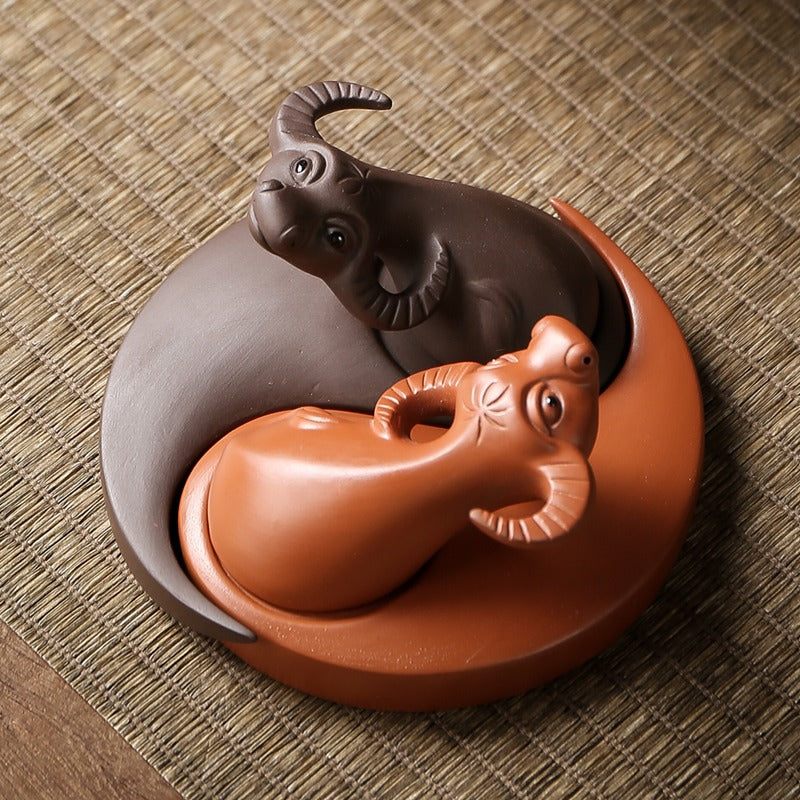 Tea lover placing the Buffalo Eight Diagrams Tea Pet on a traditional tea tray