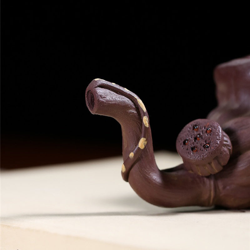 Lifestyle shot of lotus seedpod cup in use, paired with a matching Yixing teapot