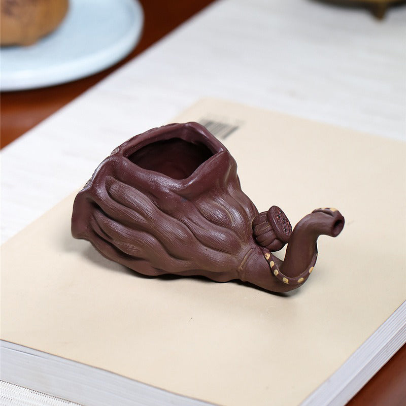 Side view of the Yixing lotus seedpod fair cup showing its handcrafted outlet stem