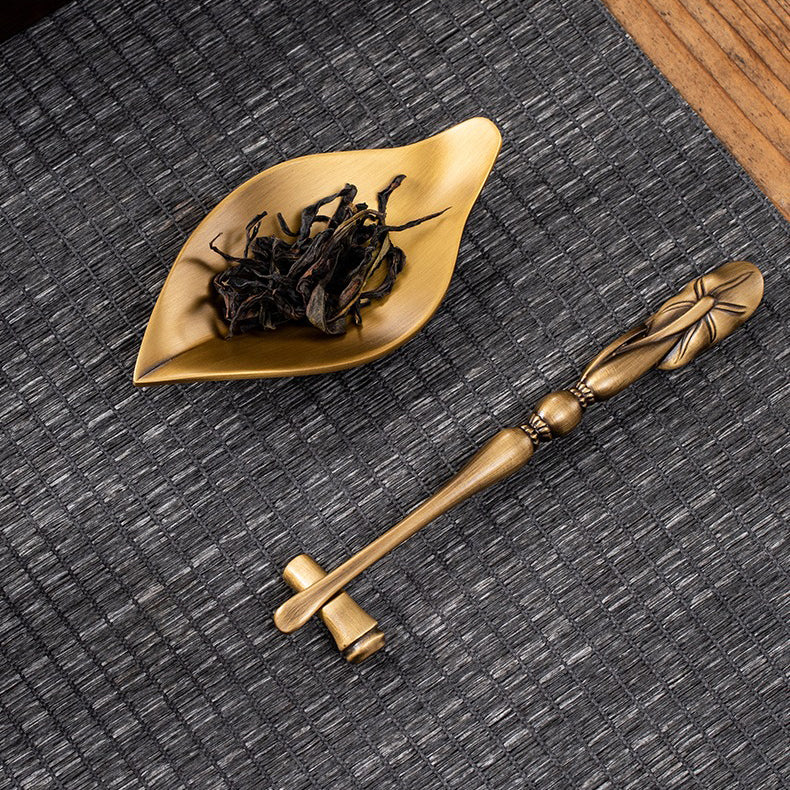 Artisan brass tea holder showcasing dry tea leaves during a tea ceremony.