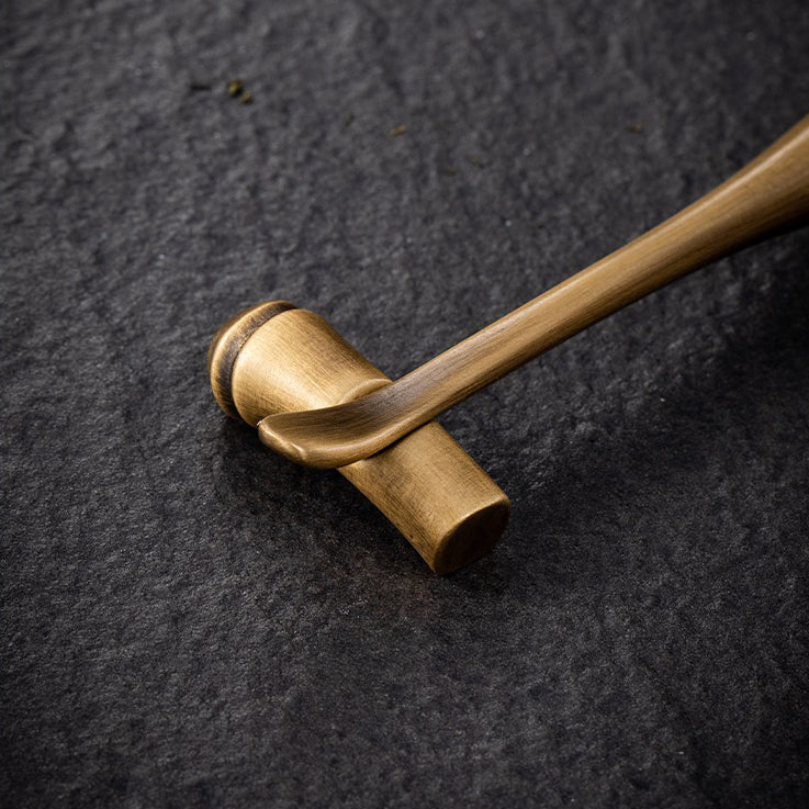 Artisan brass tea holder showcasing dry tea leaves during a tea ceremony.
