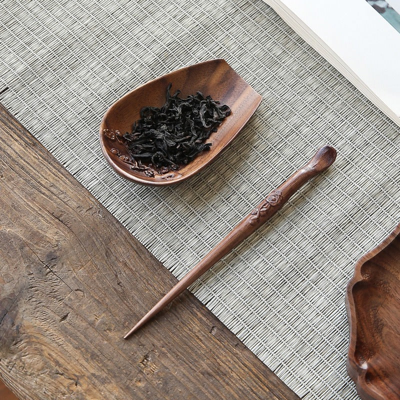 Tea ceremony setup featuring a handcrafted walnut tea utensil and tea needle