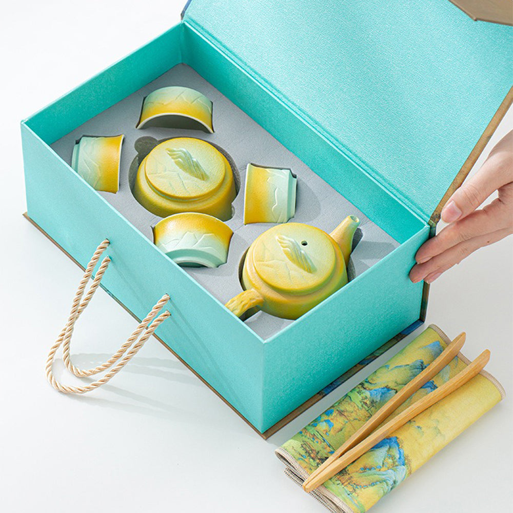 Close-up of mountain and river themed ceramic tea set showcasing vibrant glaze