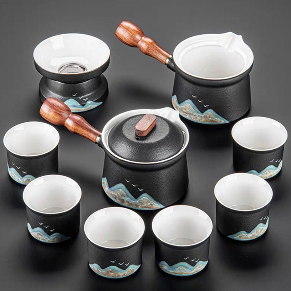 Close-up of the black ceramic teapot with mountain and bird design, showing detailed painting