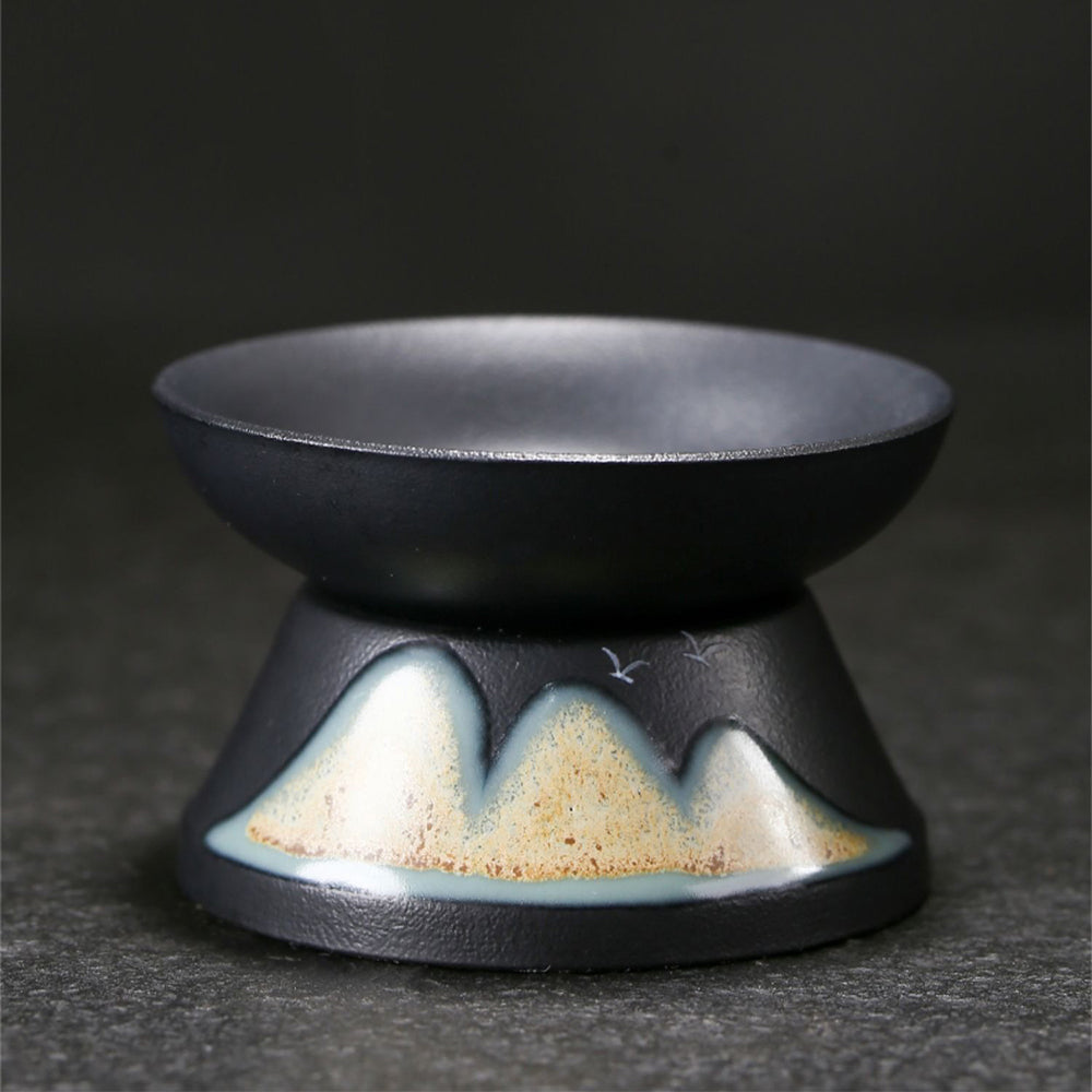 Set of six tea cups with natural landscape artwork, placed on a wooden table
