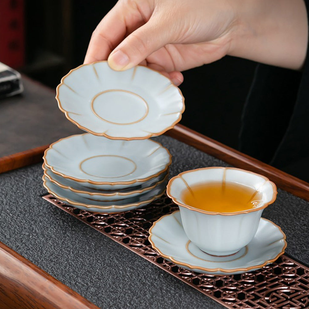 Set of elegant flower tea set with gaiwan, tea cups, and saucers displayed on a wooden table, perfect for home decor