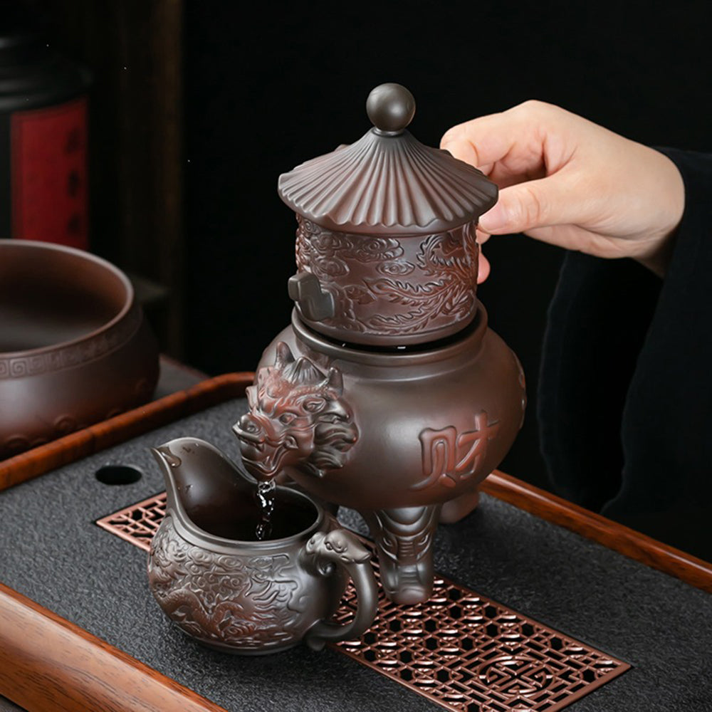 Close-up of the dragon teapot pouring tea smoothly into a fair cup, highlighting its automatic feature.