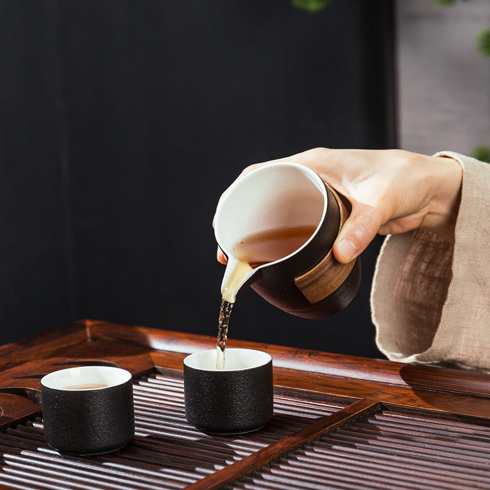 Close-up of black pottery teapot with wooden handle for kung fu tea brewing