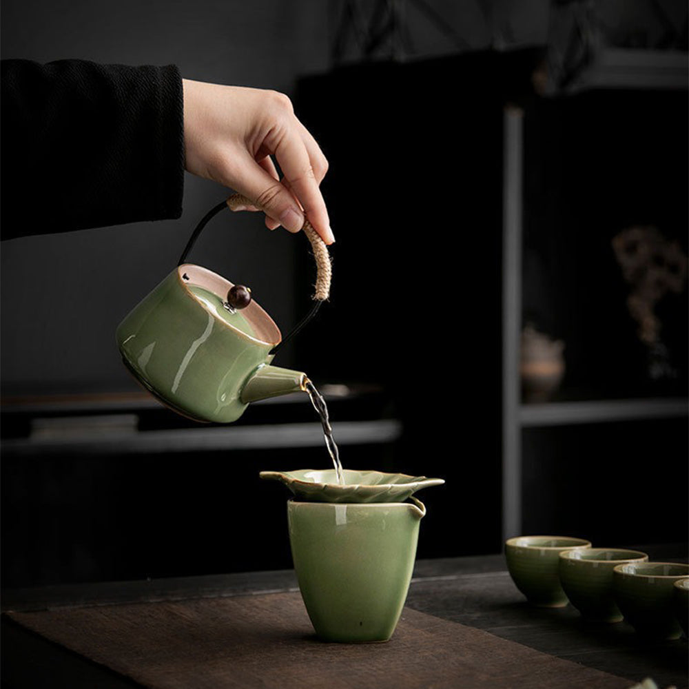 Tea cups from the Japanese celadon set arranged with tea leaves and flowers.