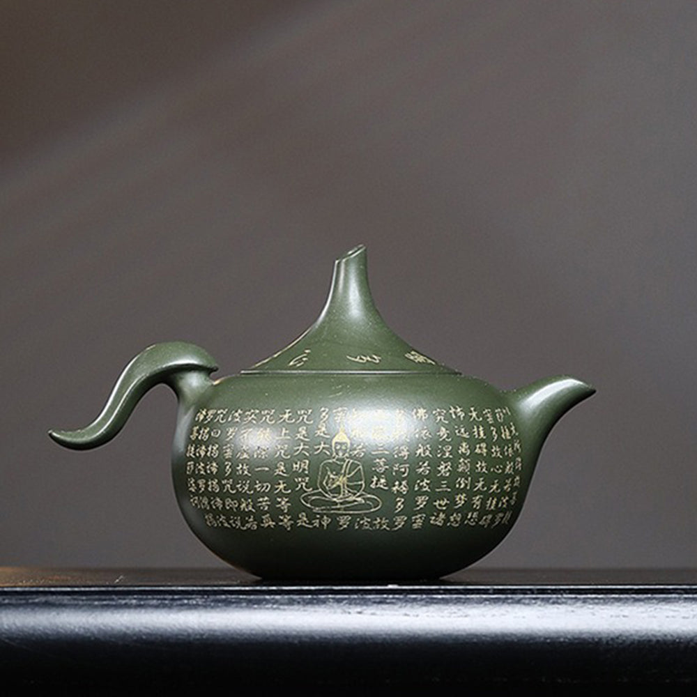 Close-up of the scriptures hand-painted on a green clay teapot for tea lovers