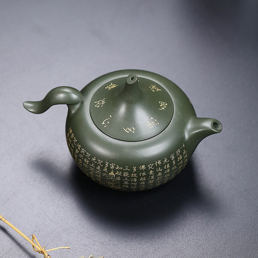 Yixing green clay teapot pouring tea with a smooth spout and ergonomic handle