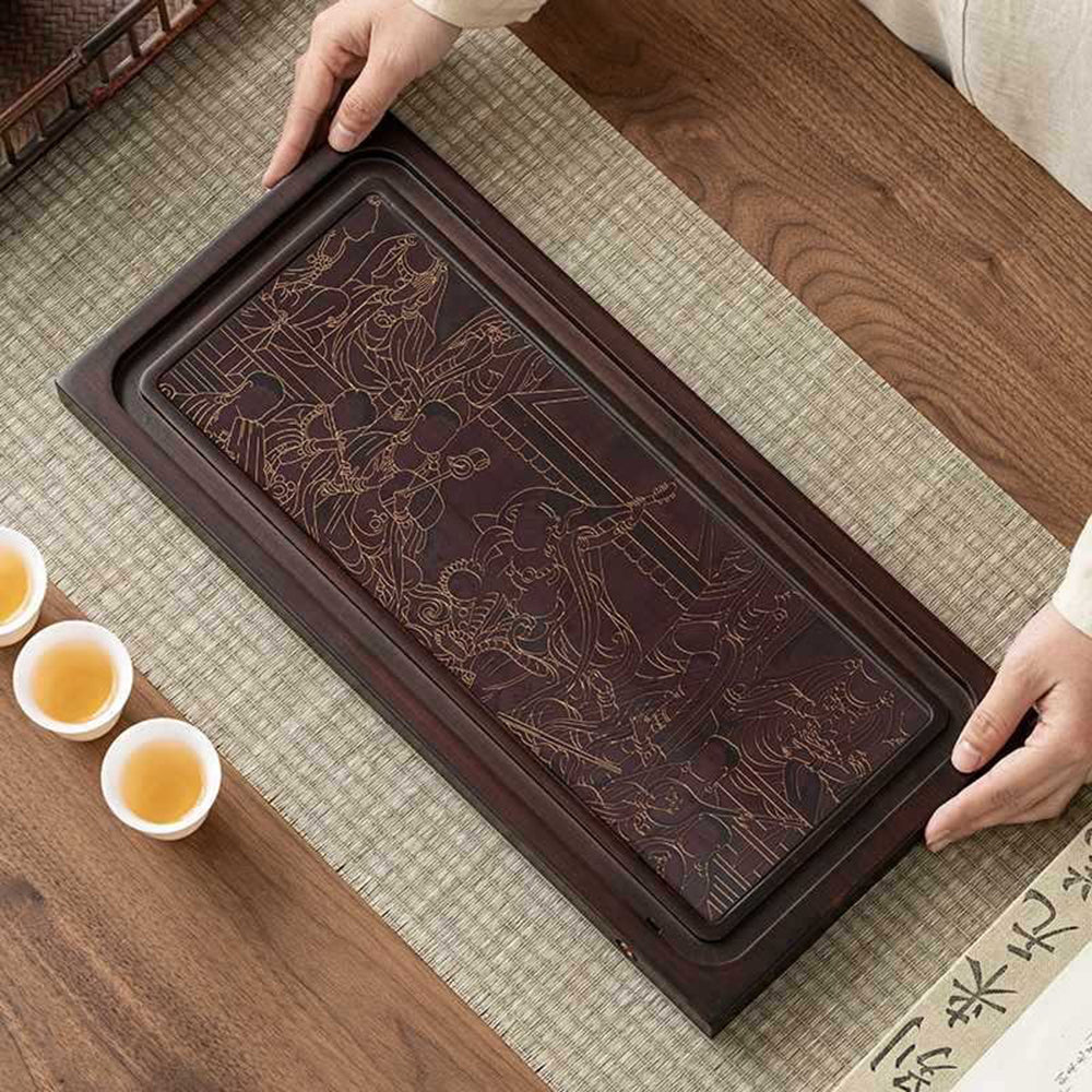 Close-up of the vibrant designs on the bamboo tea tray after brewing tea