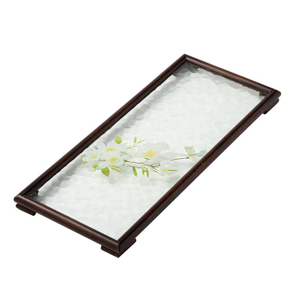 Close-up of water ripple glass surface with floral design on walnut tea tray