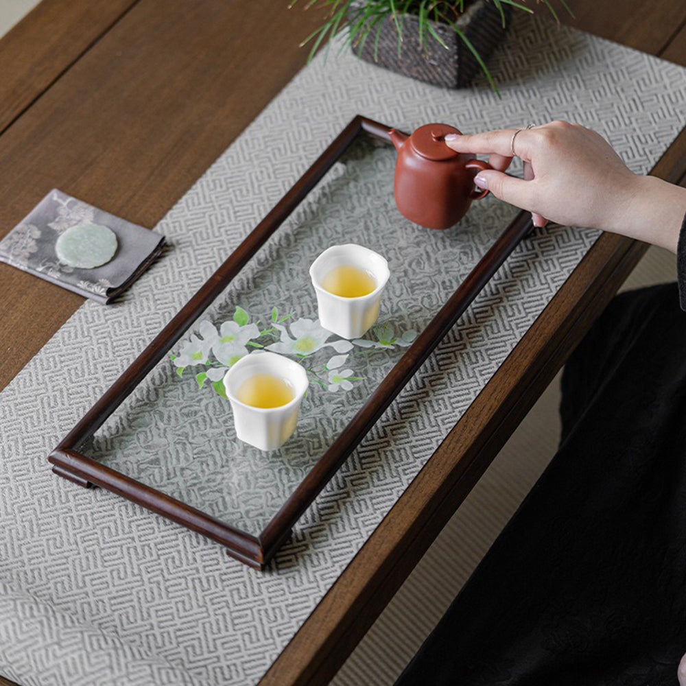 Serving tea on a stylish walnut glass ripple tea tray with floral accents