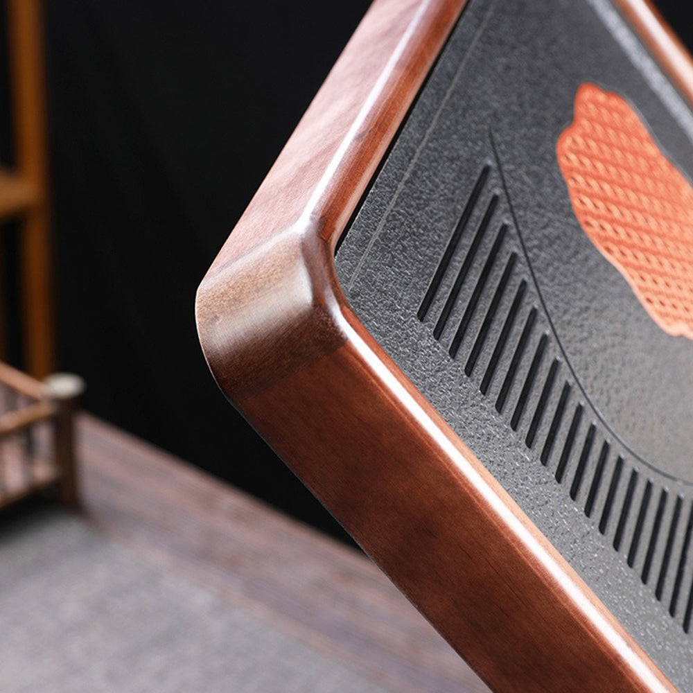 Close-up of the removable panel of the wooden tea tray, showcasing the drainage system.