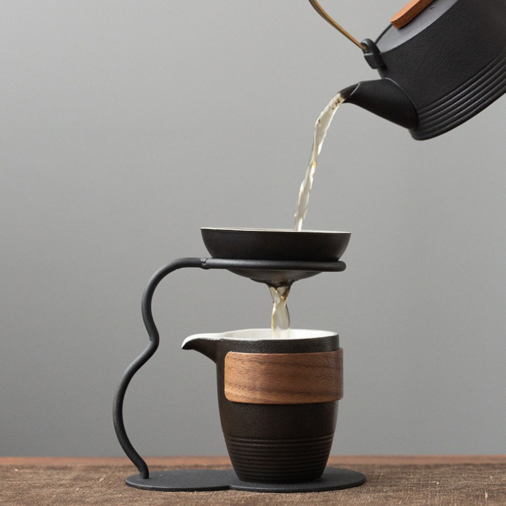 Side view of black pottery tea strainer set showing walnut-wrapped fair cup and maple leaf detailing