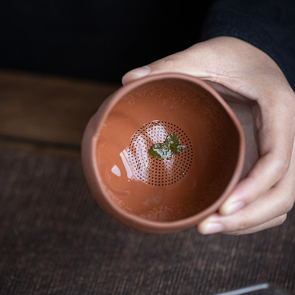 Tea pet and strainer set with the snail holding a tea leaf brew, showcasing its cute design