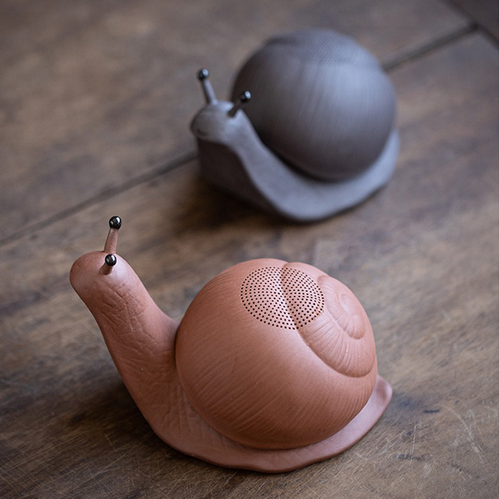 Disassembled purple clay snail tea pet showing the easy-clean filter inside