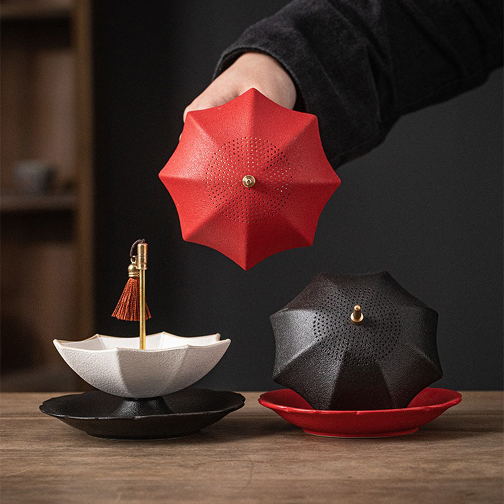 Charming ceramic umbrella tea strainer on a tea cup, showcasing its unique design.