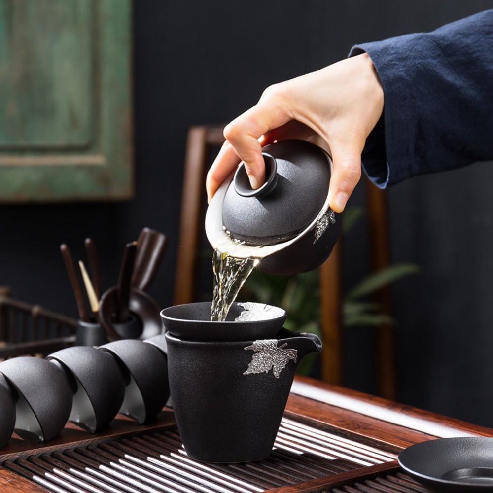 Detailed view of black pottery teapot and cups highlighting traditional craftsmanship