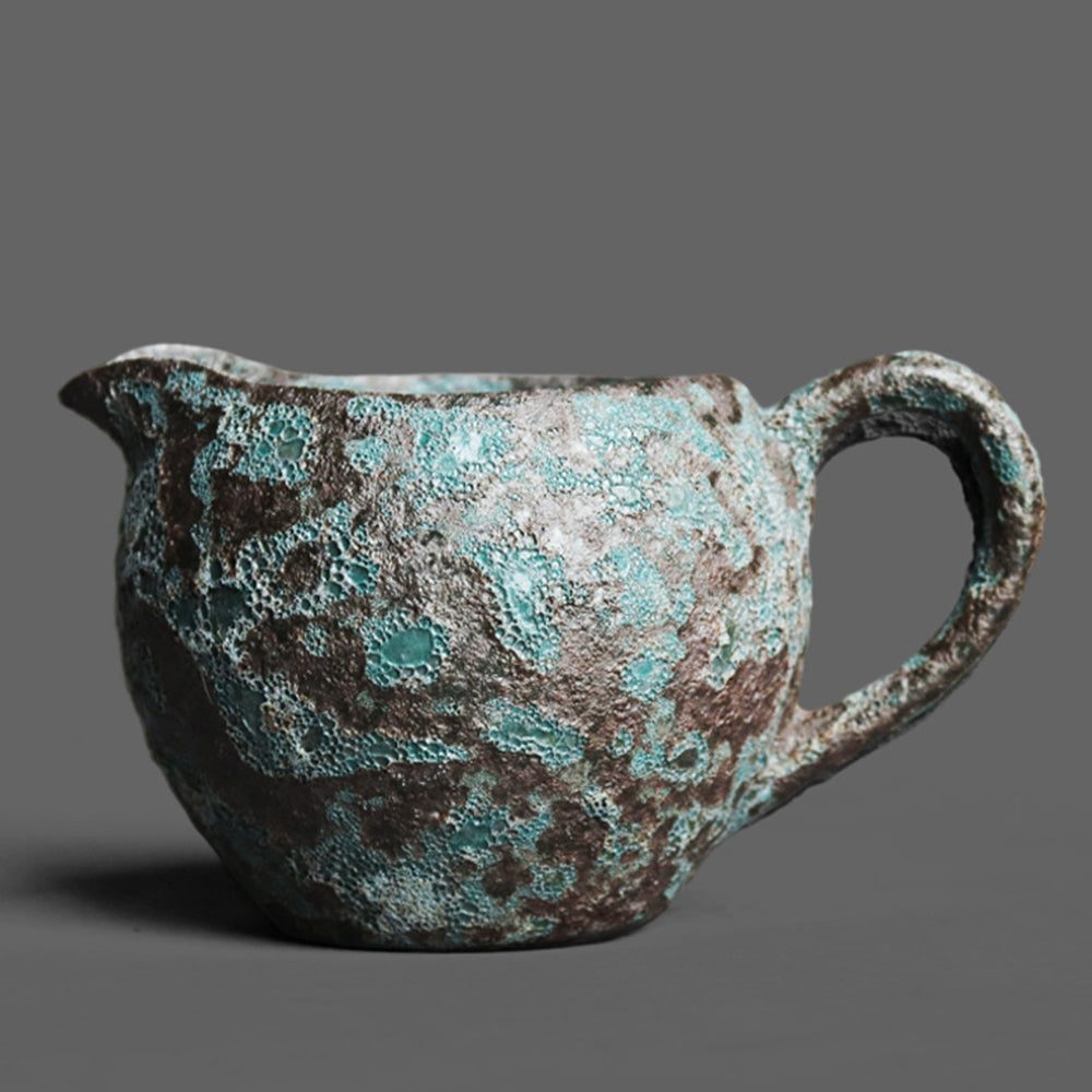 Close-up of vintage bronze coarse pottery fair cup showing textured bronze glaze