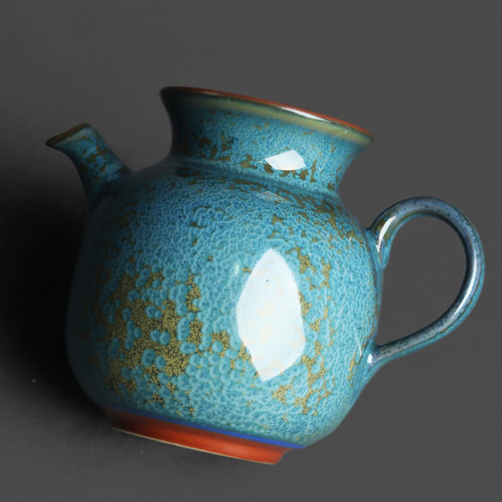 Side view of the ceramic fair cup with a focus on the handle and spout for tea brewing