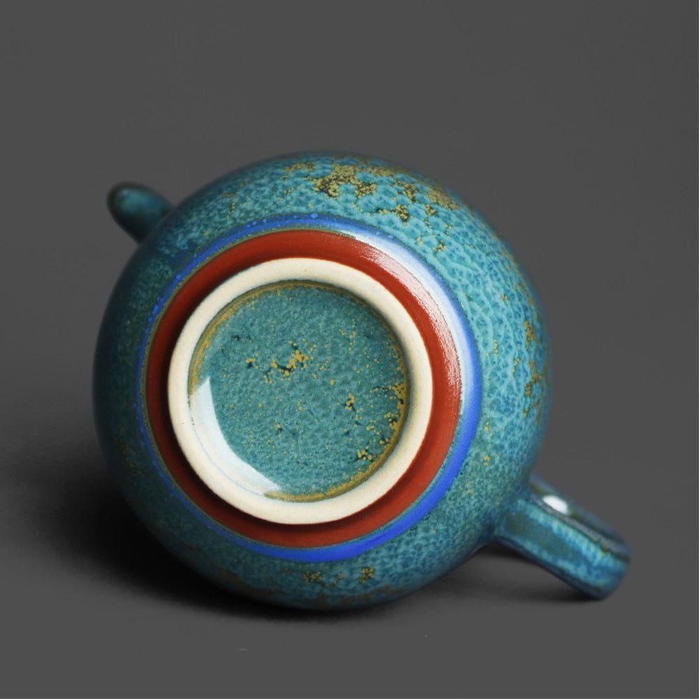Side view of the ceramic fair cup with a focus on the handle and spout for tea brewing