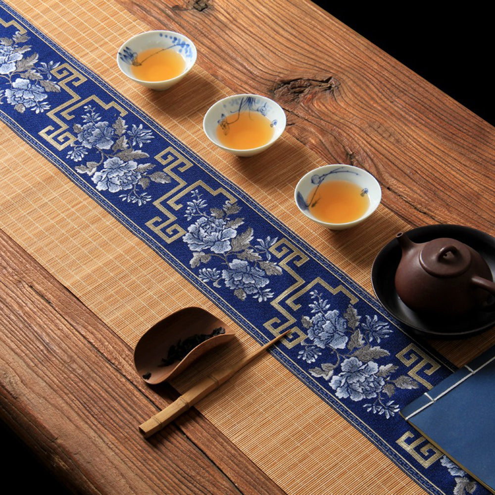 Close-up of floral embroidery on a bamboo tea mat, showcasing intricate stitching and vibrant colors