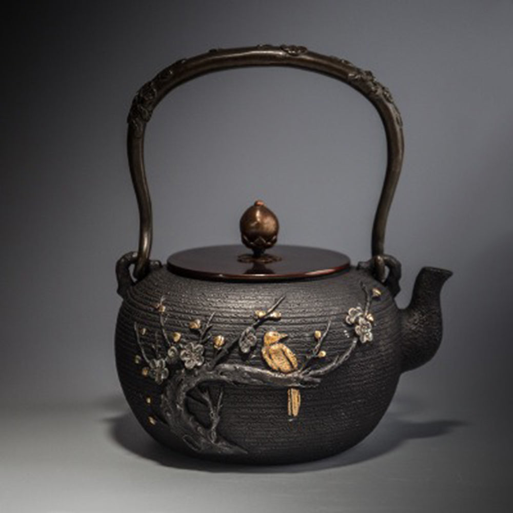 Close-up of the luxurious gold-plated patterns on the cast iron teapot lid.