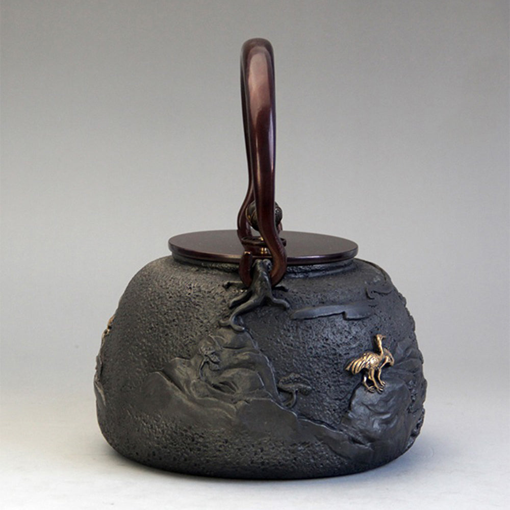 Close-up of the intricate design on the handmade cast iron teapot, emphasizing craftsmanship.