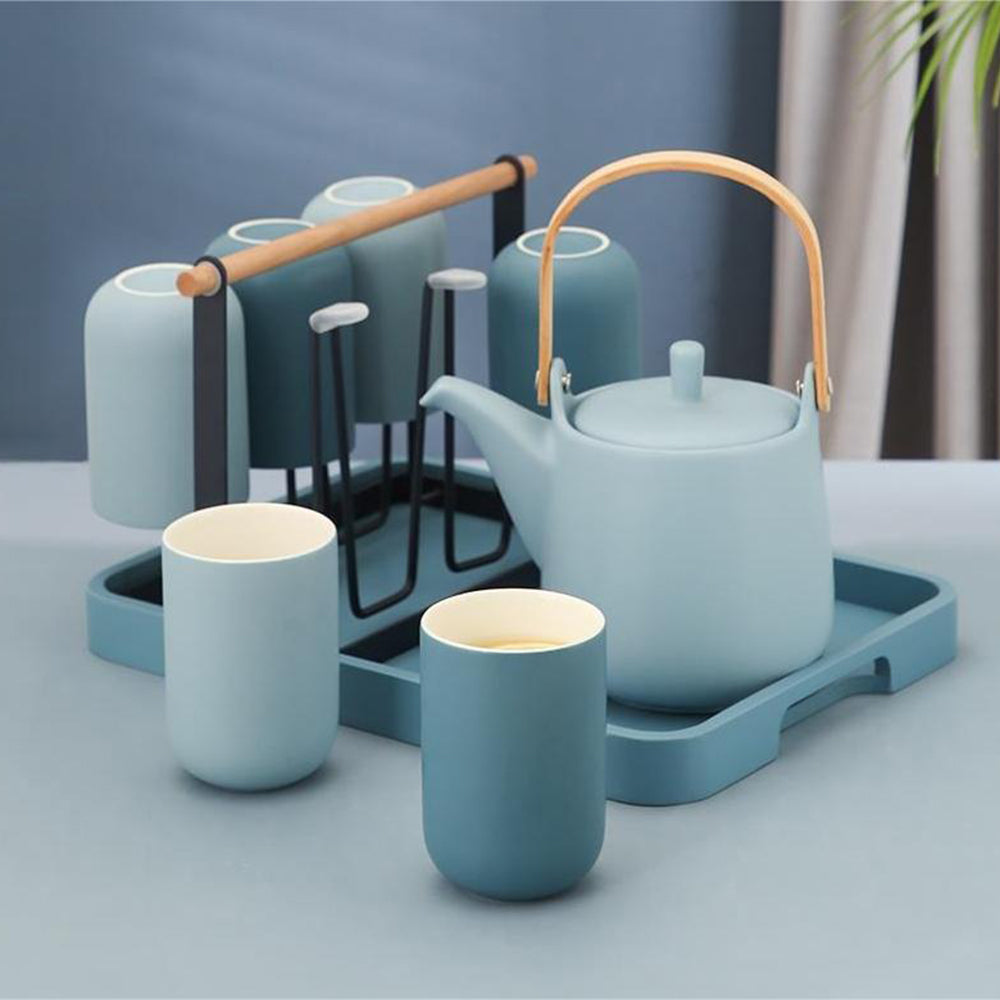 Overhead view of ceramic tea set with 6 cups arranged neatly on the wooden tray