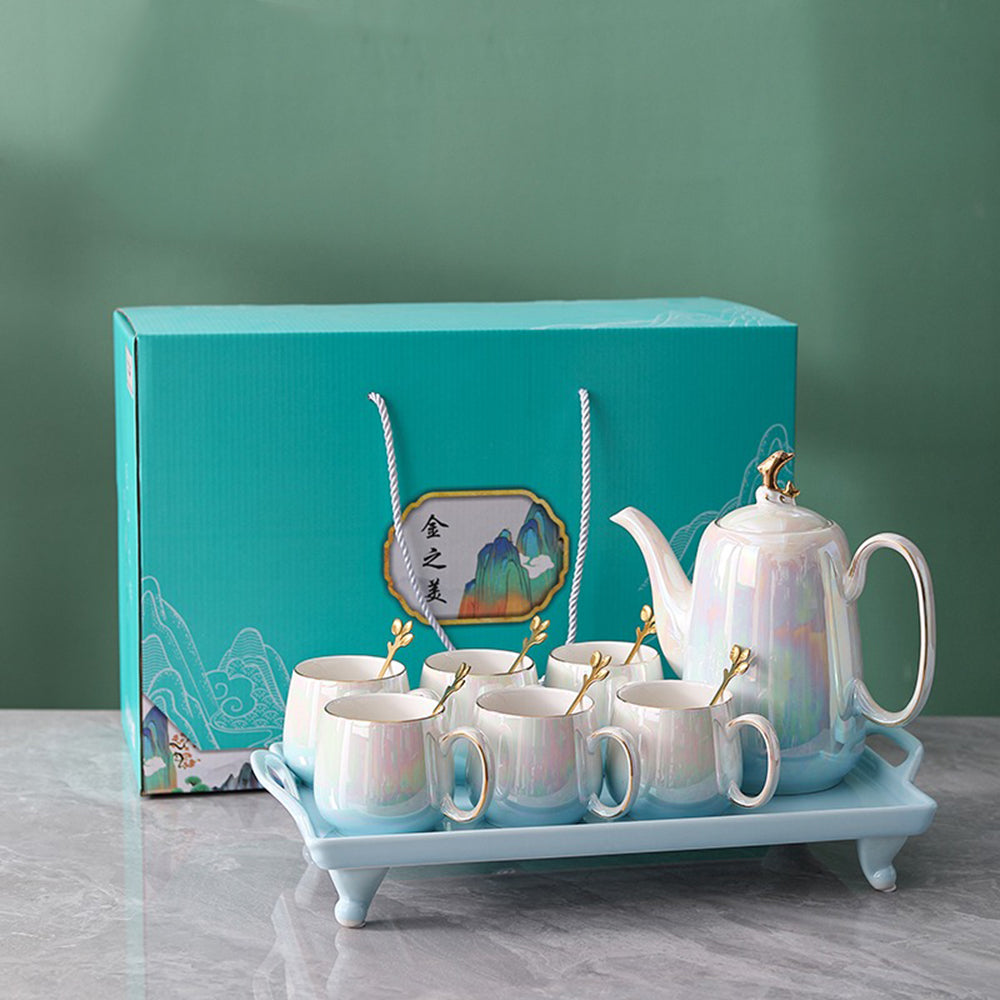 Close-up of the elegant gold dolphin handle on the teapot of the luxury tea set.