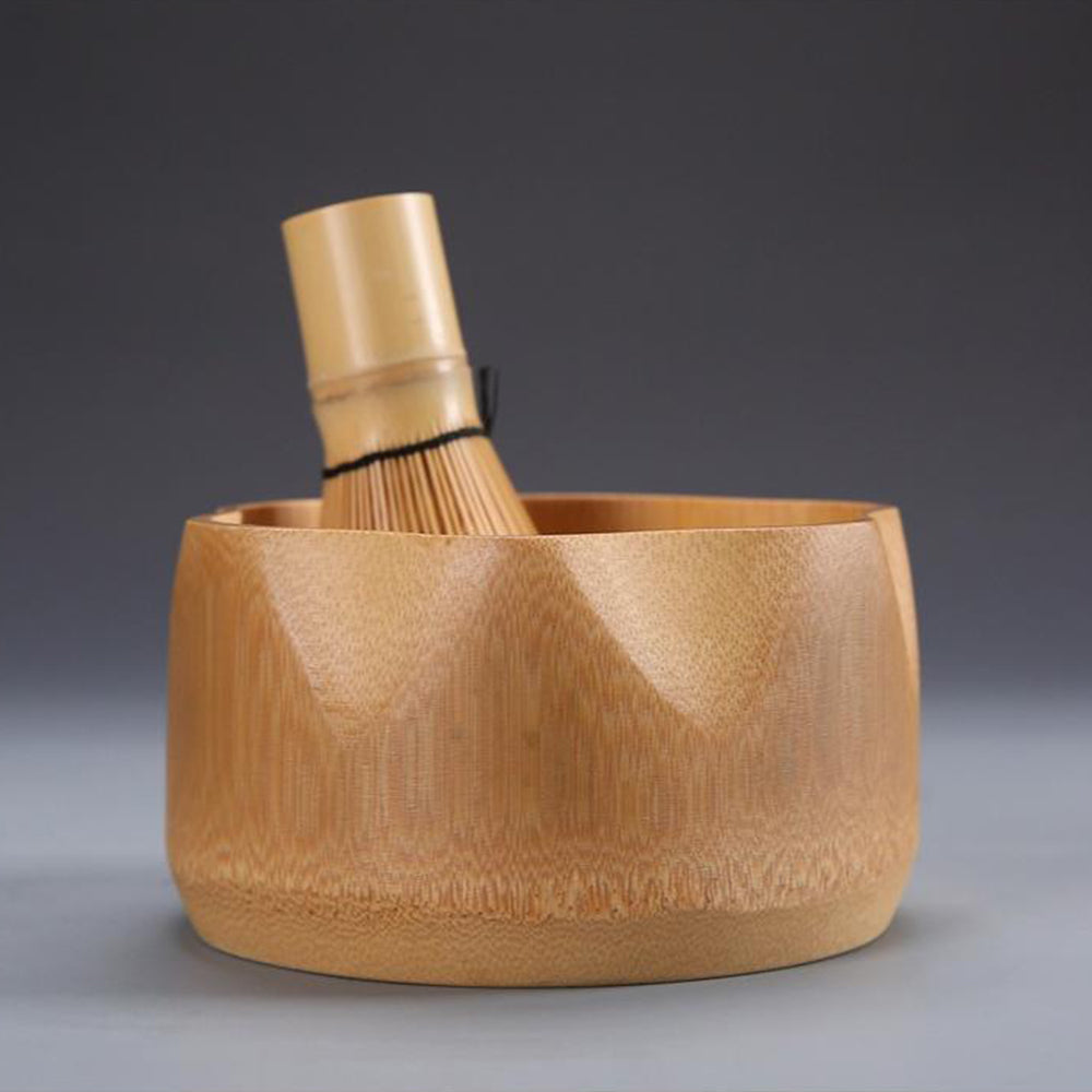 Ceramic whisk stand holding the bamboo whisk next to the bamboo bowl, emphasizing the complete tea ceremony set.