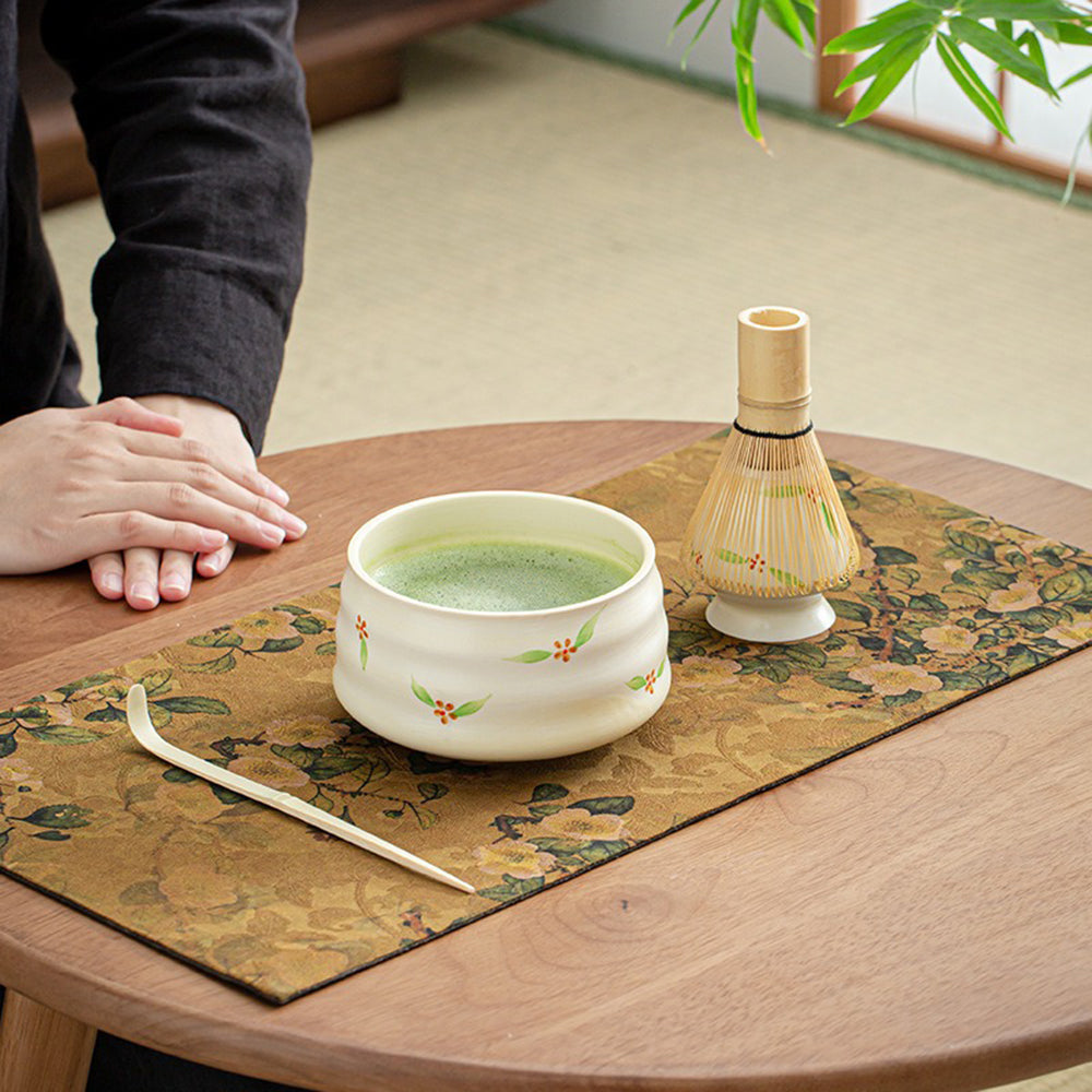 Elegant Japanese matcha tea set featuring a bamboo whisk and ceramic bowl.
