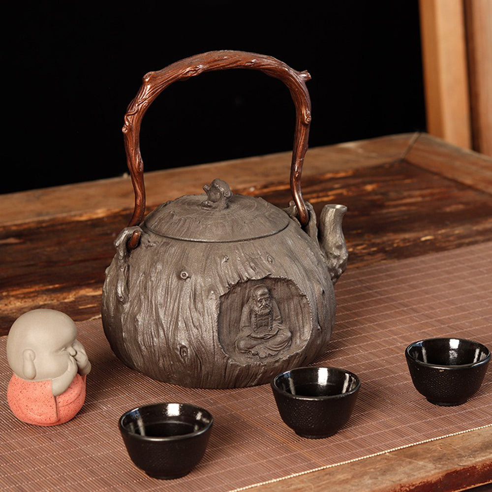 Front view of traditional cast iron teapot with textured surface and copper handle