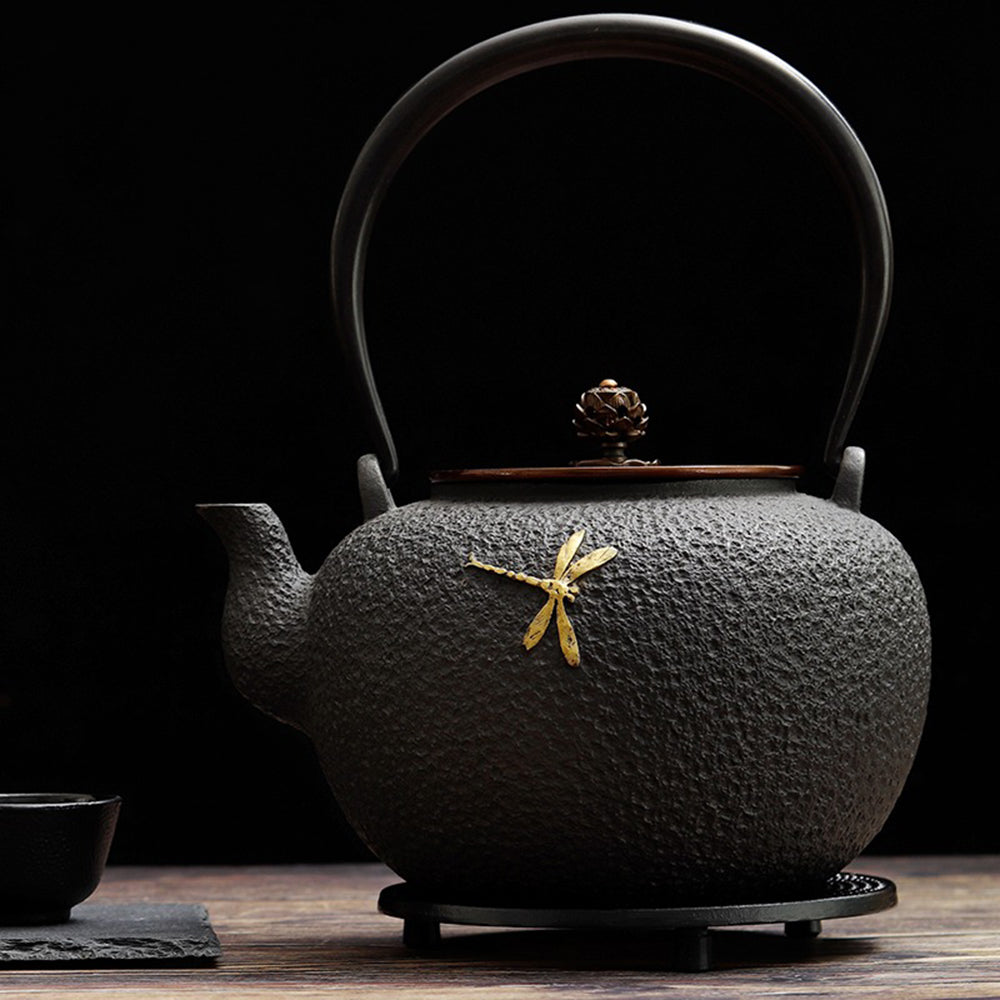 Artisan Dragonfly Cast Iron Teapot with copper handle, beautifully crafted for tea brewing.