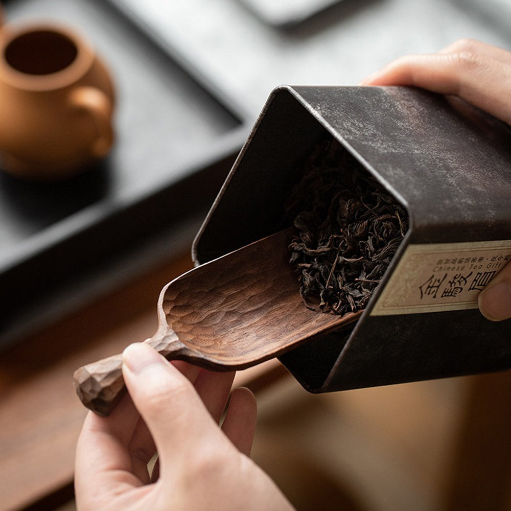 Person holding a handcrafted walnut tea holder for tea tasting