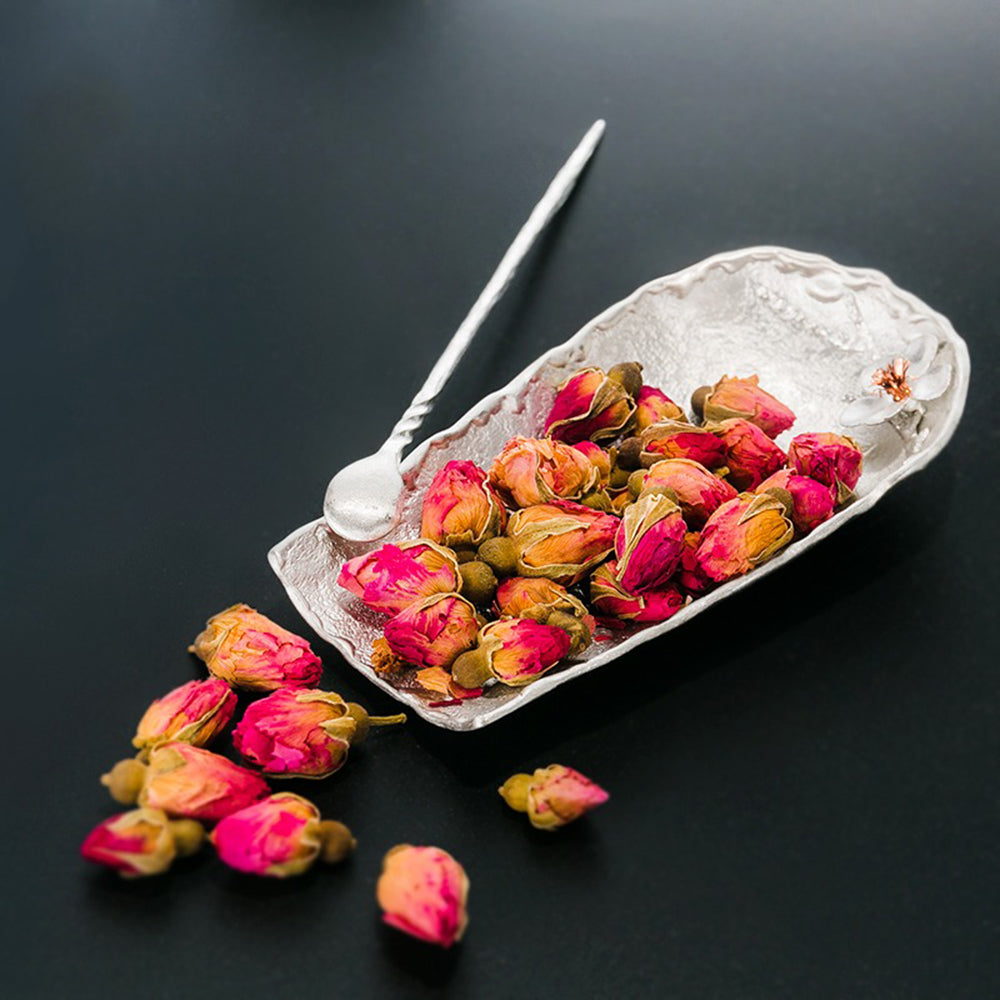 Elegant tin tea holder with spoon and stand, showcasing plum blossom design.