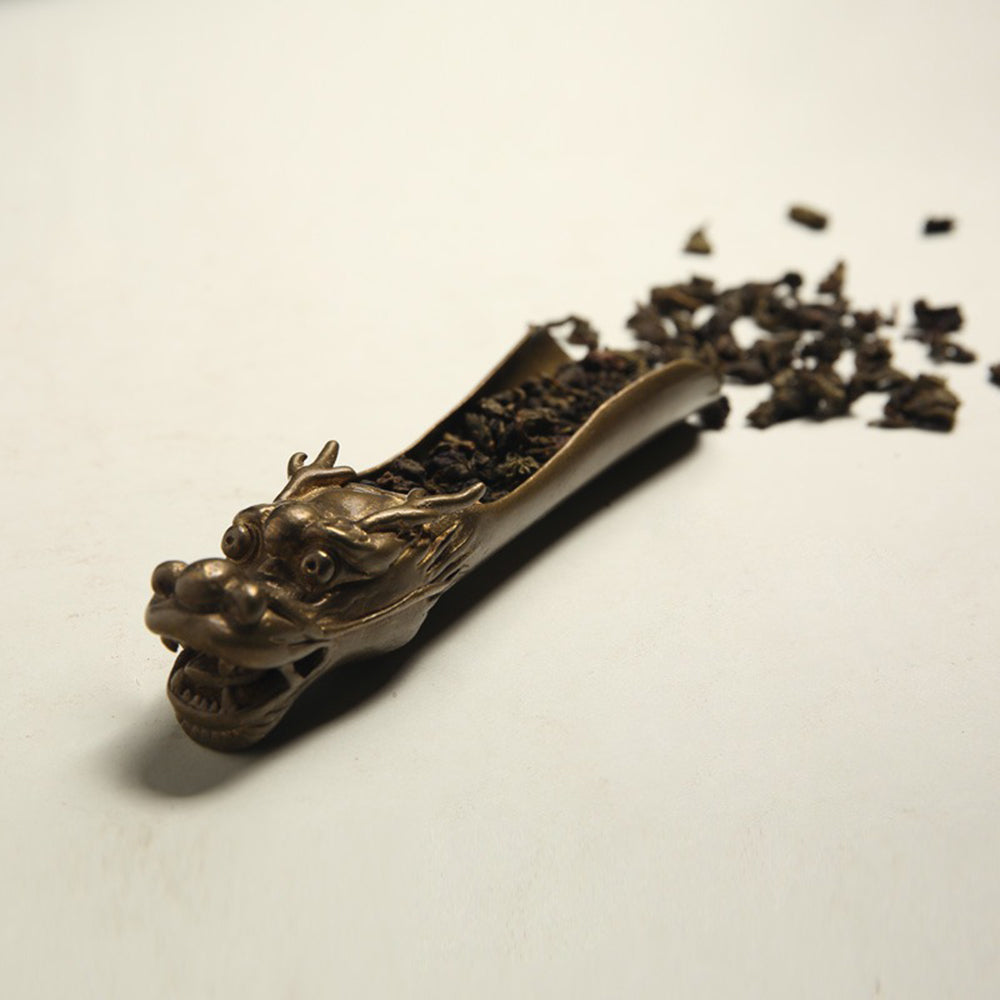 Close-up of the handmade brass tea leaf divider with dragon design, showing detailed craftsmanship