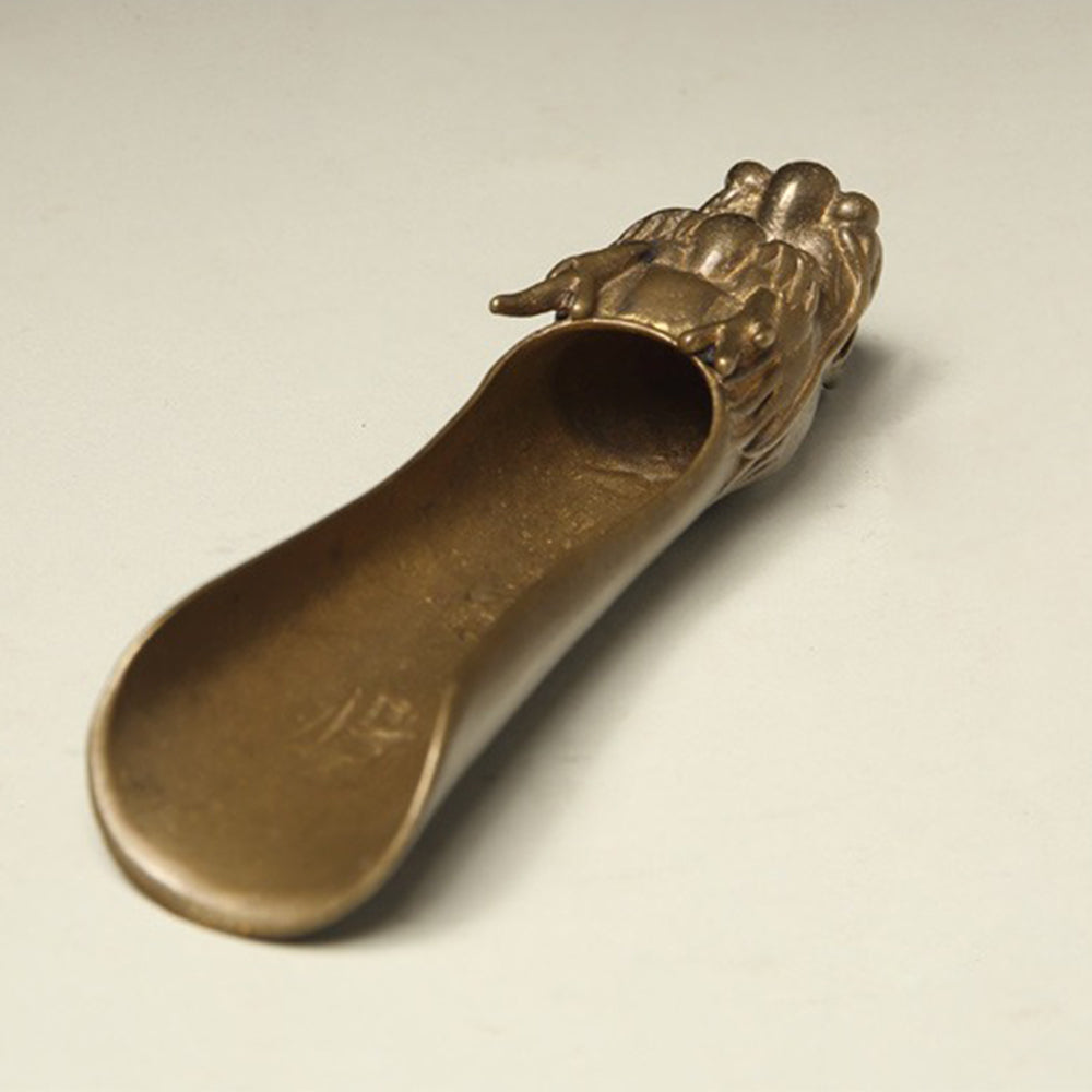 Close-up of the handmade brass tea leaf divider with dragon design, showing detailed craftsmanship