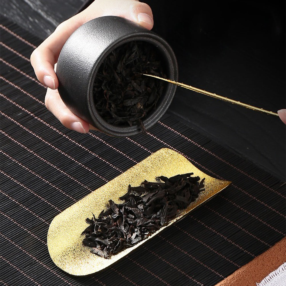 Stylish alloy cha he and spoon set on a wooden tea table