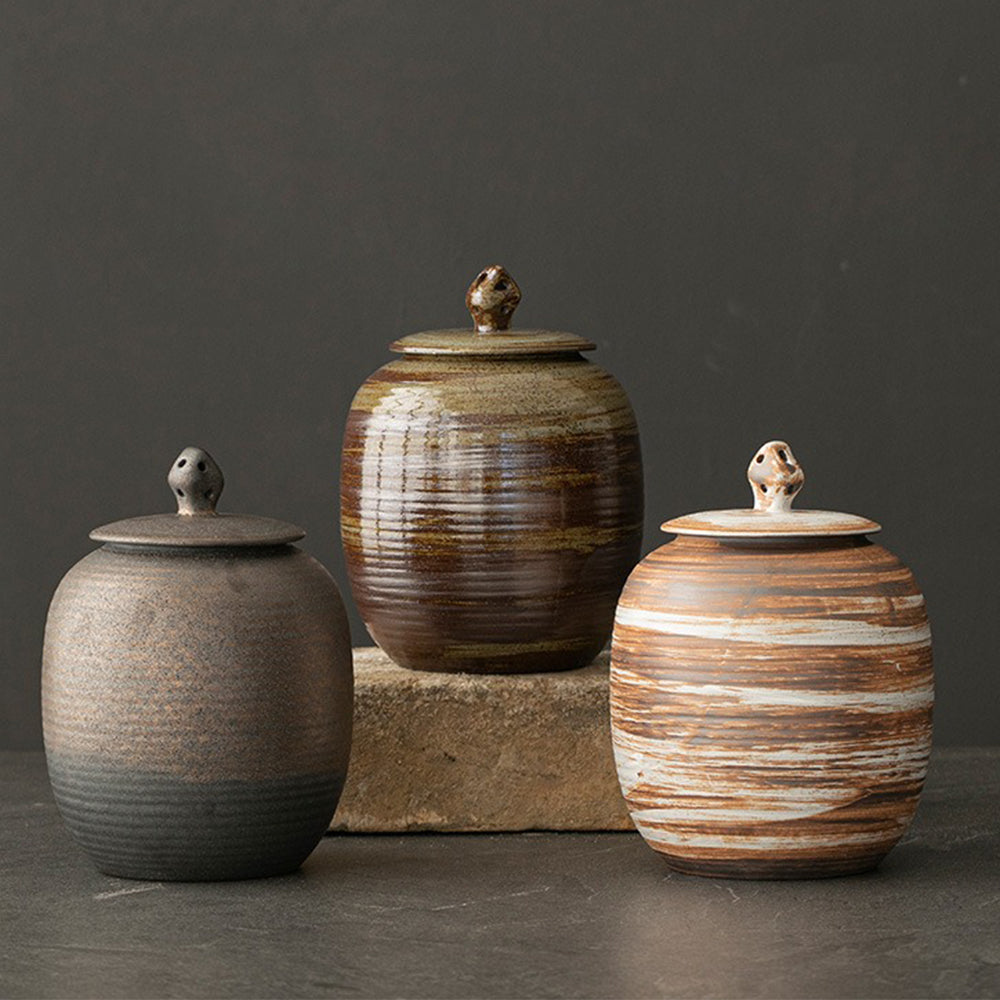 Close-up of the handmade pottery tea caddy with a lid, highlighting the unique glaze and texture.