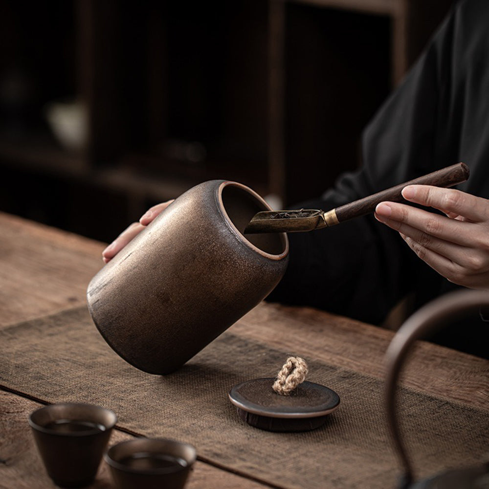 Side view of coarse pottery tea container with lid open, highlighting sealing and craftsmanship