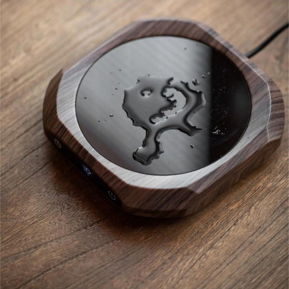 Portable tea warmer in use on office desk with ceramic mug