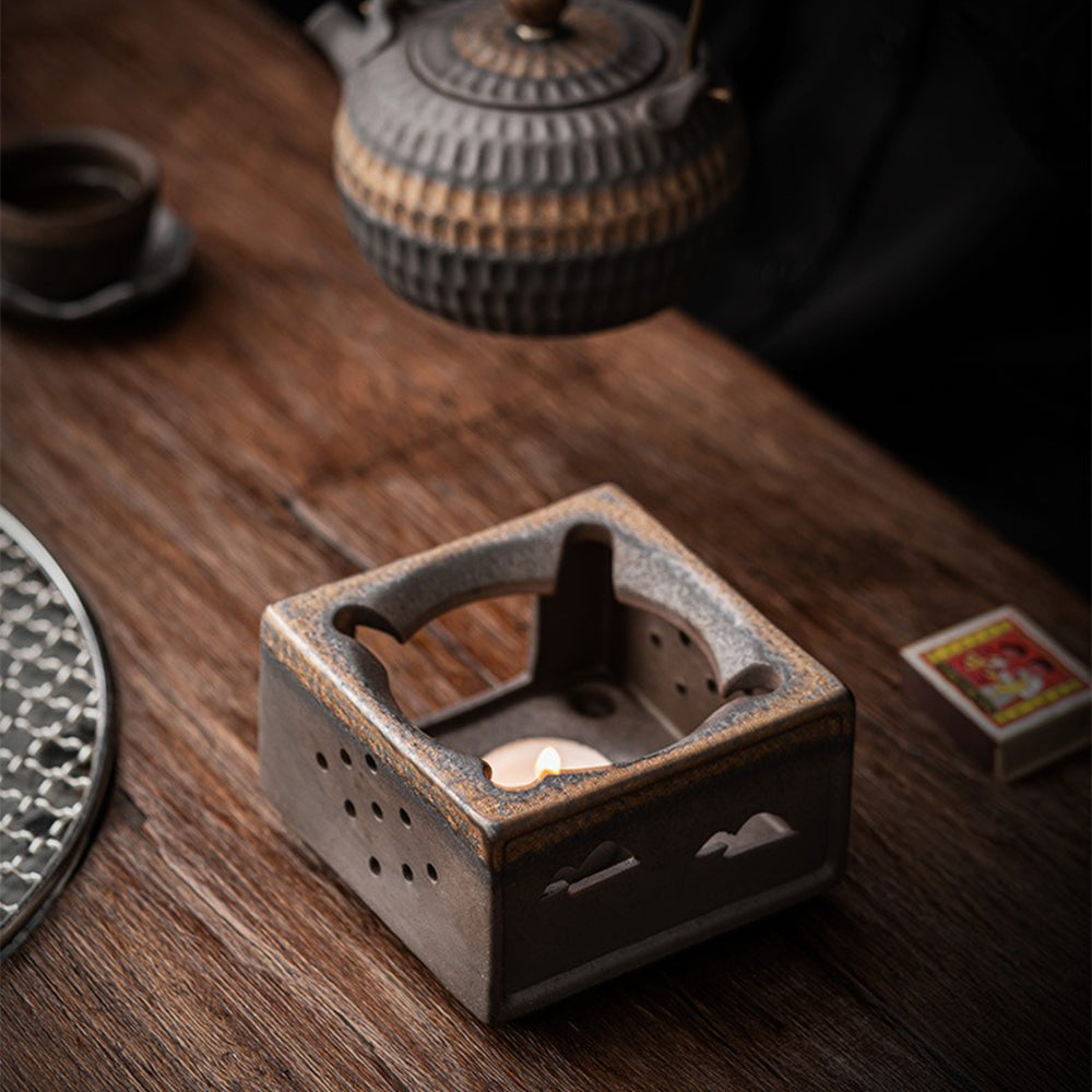 Teapot placed on the pottery warmer during a cozy breakfast setting