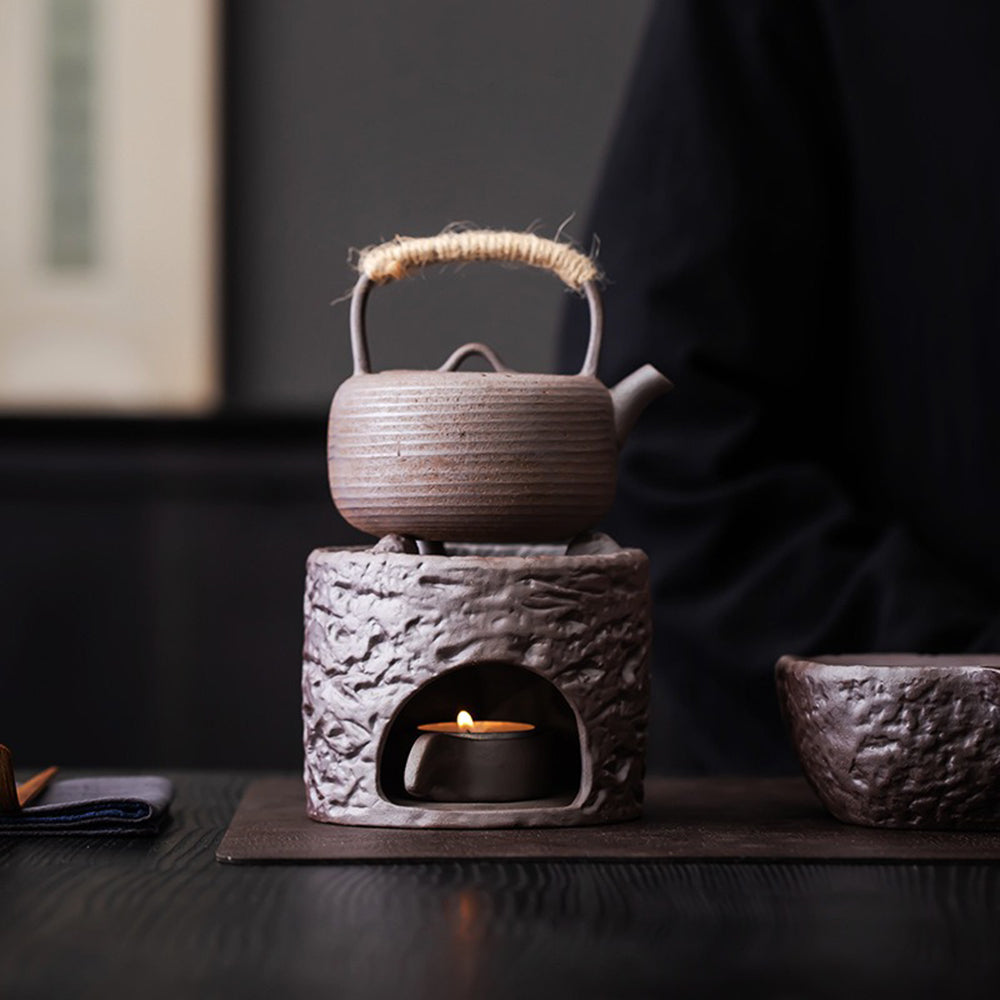 Close-up of textured handmade pottery teapot with frosted glaze and hemp handle