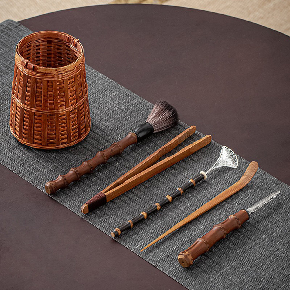 Close-up of alloy tea spoon and bamboo tea utensils on wooden table